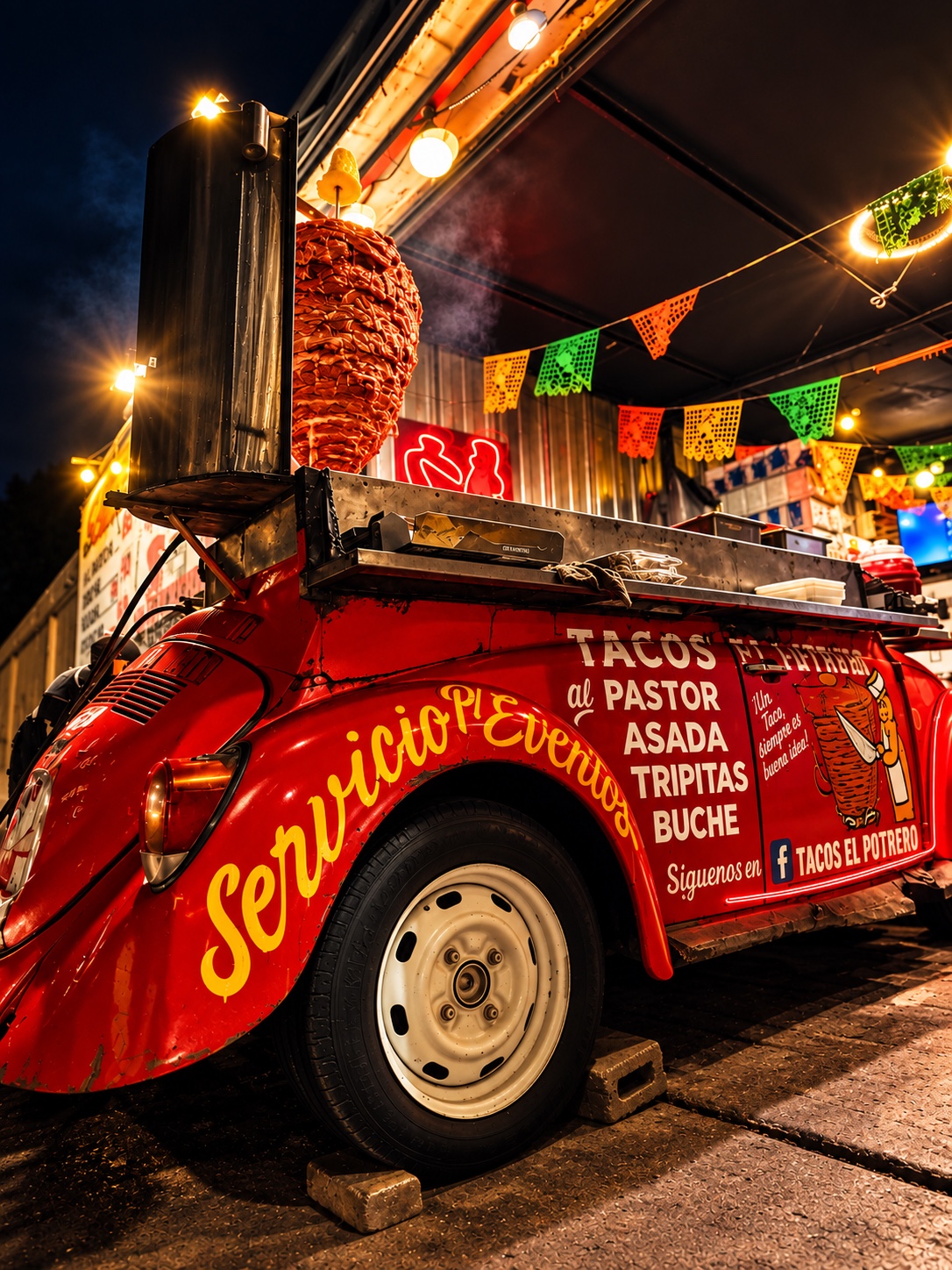 Carro de tacos rojo de Tacos El Potrero de noche, con trompo al pastor y luces cálidas